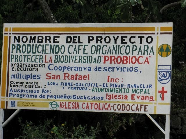 Road sign for the San Raphael Cooperative indicating the member groups and two of their core tenets, organic growing and biodiversity preservation. Photo by Barth Anderson.